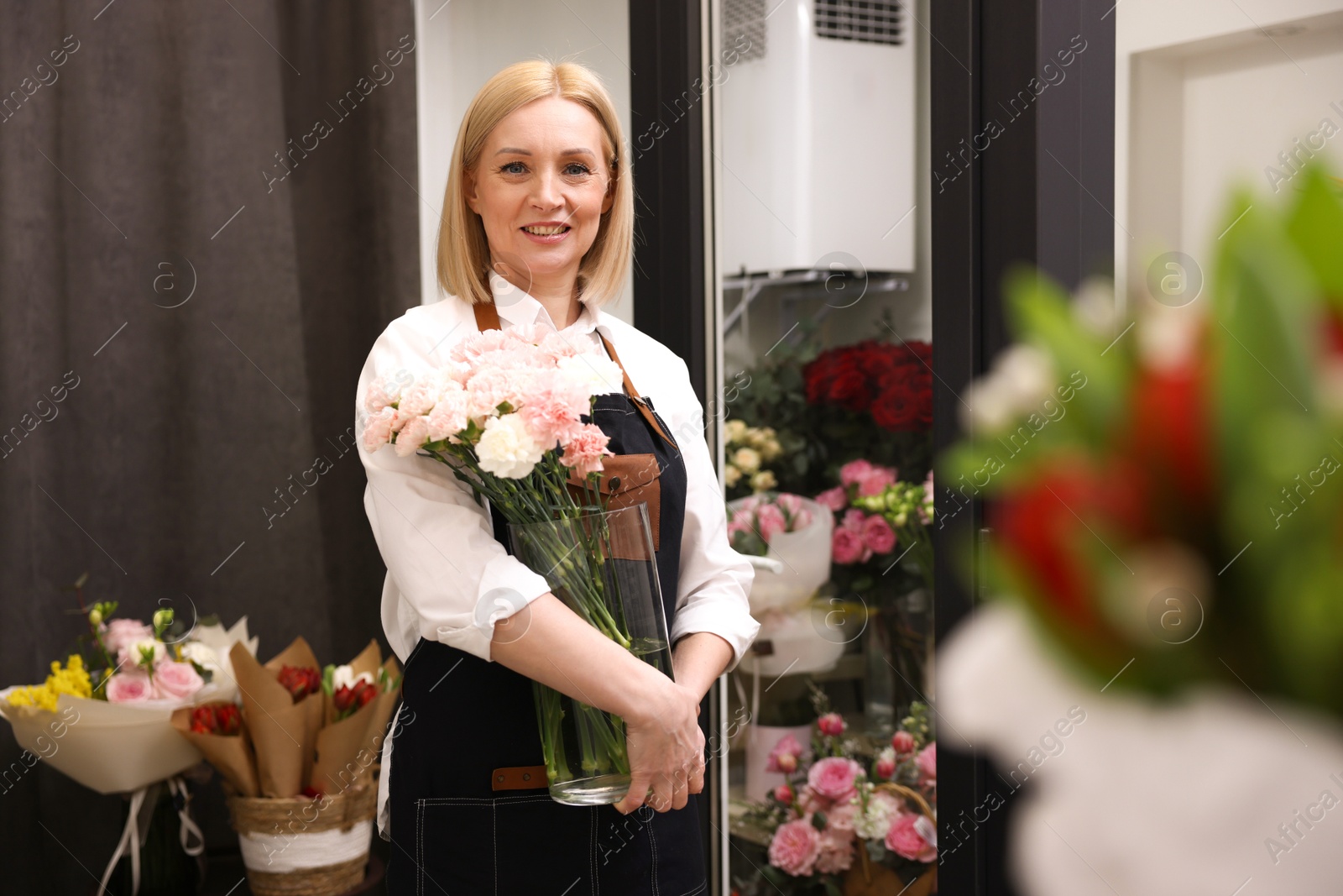 Photo of Business owner with beautiful carnations in her flower shop