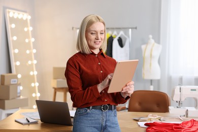 Photo of Business owner with tablet in her tailor shop