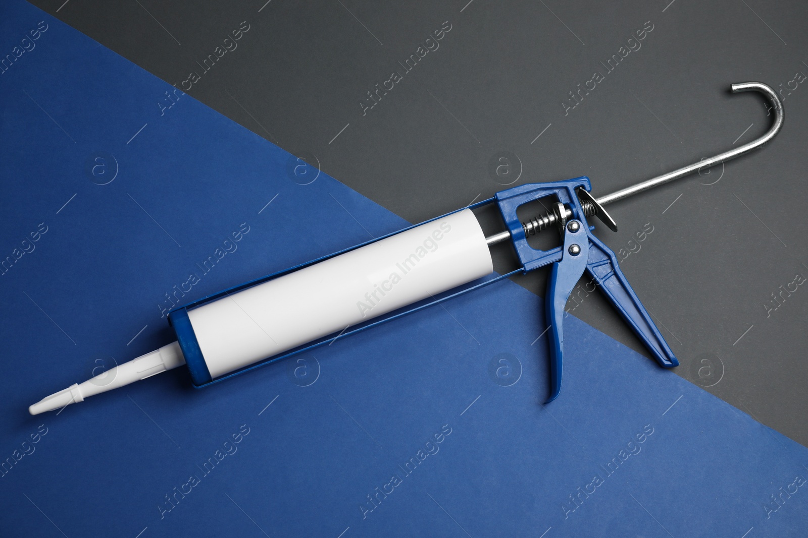 Photo of One glue gun on color background, top view