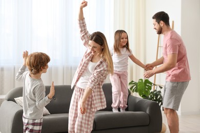 Happy family wearing stylish pajamas having fun at home