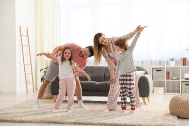 Happy family wearing stylish pajamas having fun at home