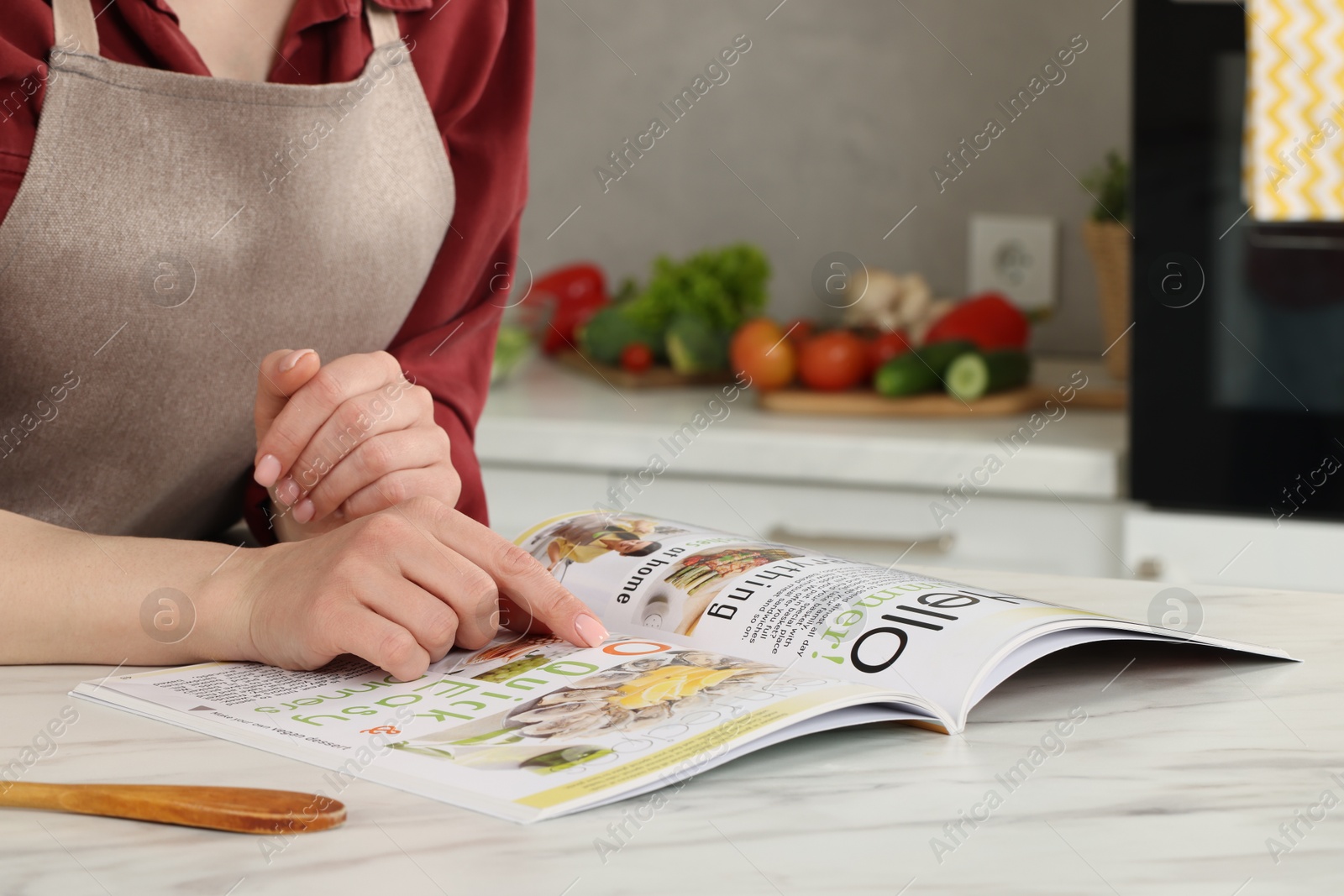 Photo of Woman reading recipe in culinary magazine at home, closeup. Space for text