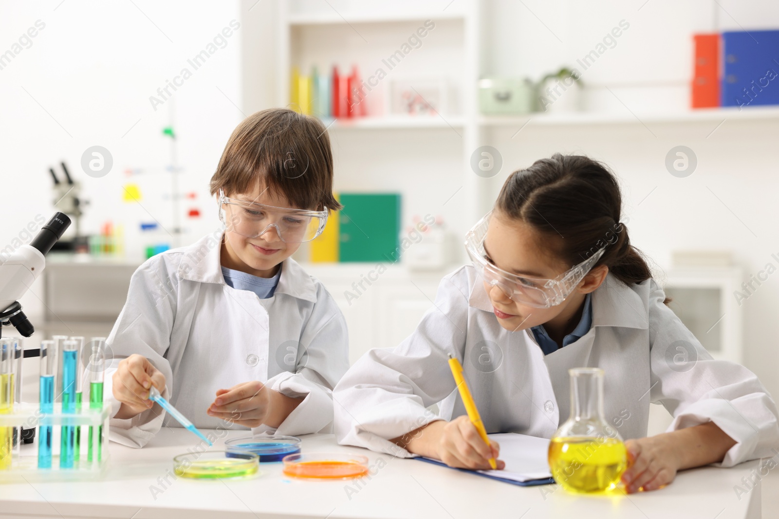 Photo of Children doing chemical experiment at desk indoors