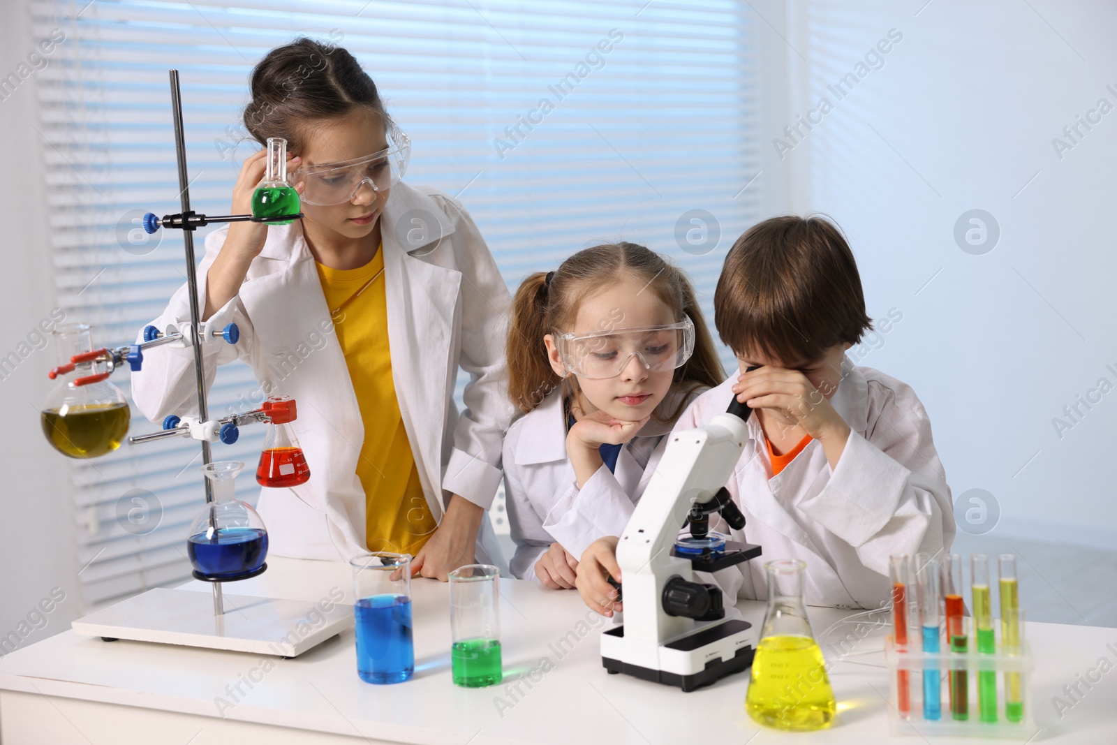 Photo of Children doing chemical experiment at desk indoors