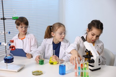 Photo of Children doing chemical experiment at desk indoors