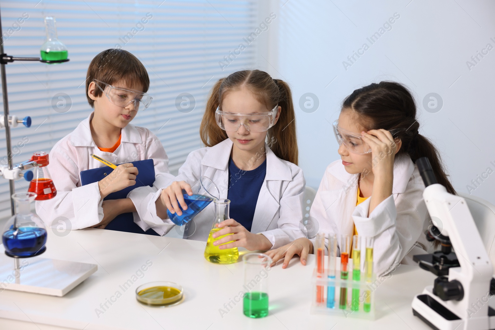 Photo of Children doing chemical experiment at desk indoors