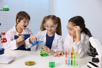 Photo of Children doing chemical experiment at desk indoors