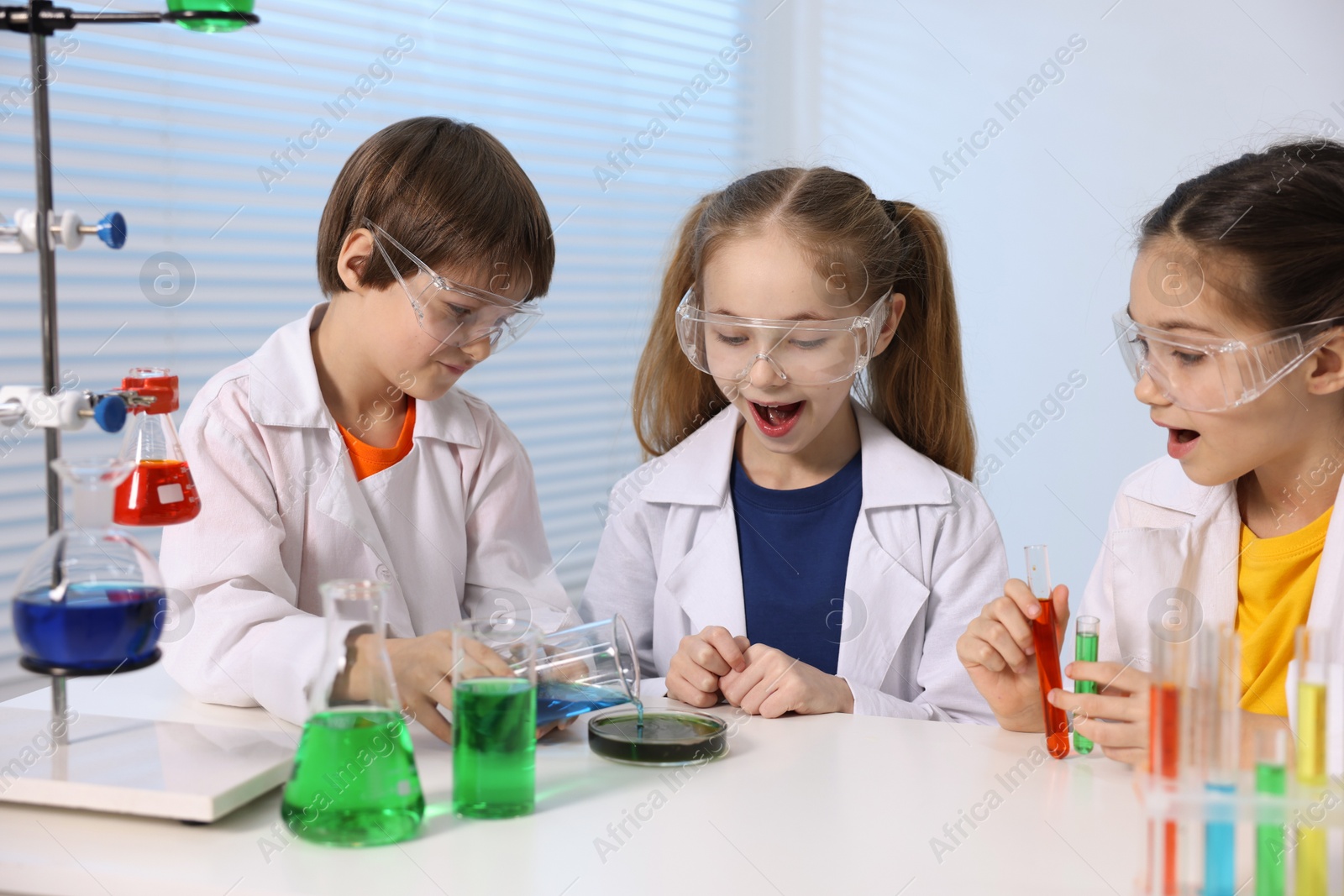 Photo of Children doing chemical experiment at desk indoors