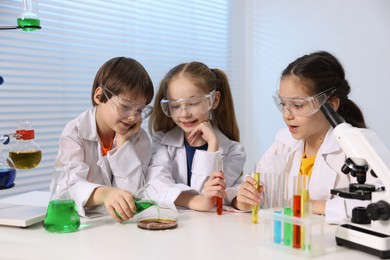 Photo of Children doing chemical experiment at desk indoors