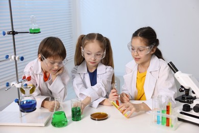 Photo of Children doing chemical experiment at desk indoors