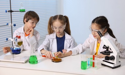 Children doing chemical experiment at desk indoors