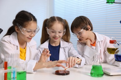 Photo of Children doing chemical experiment at desk indoors