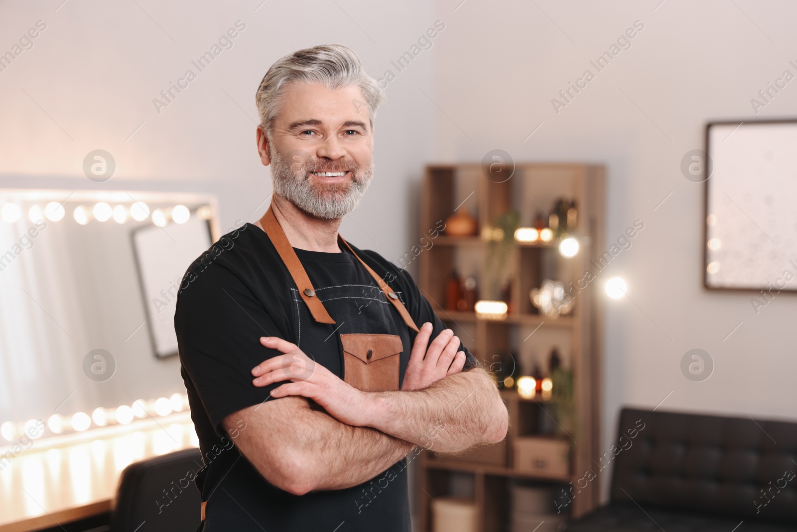 Photo of Portrait of smiling hairdresser in beauty salon. Space for text