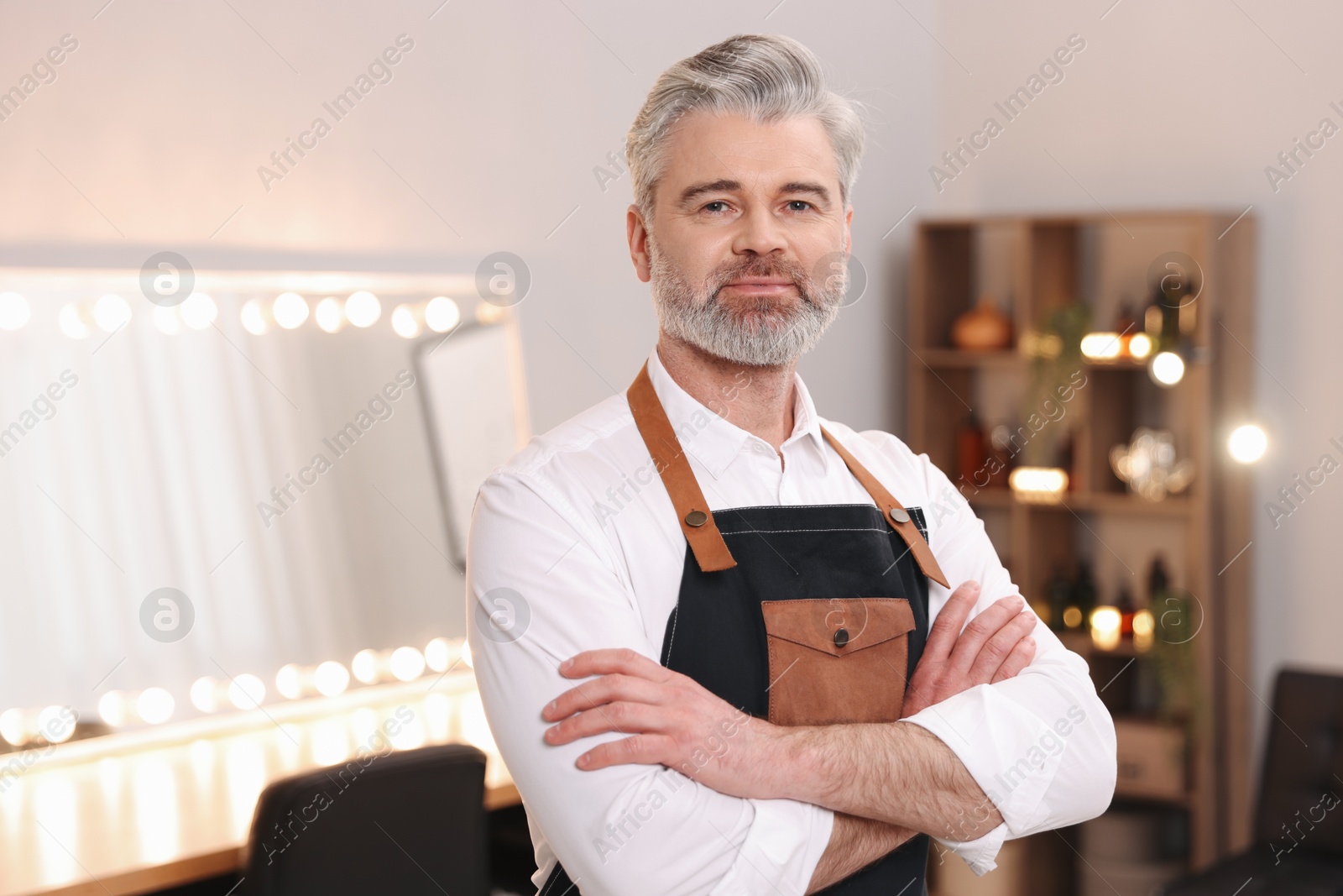 Photo of Portrait of hairdresser wearing apron in beauty salon