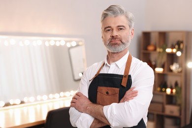 Photo of Portrait of hairdresser wearing apron in beauty salon