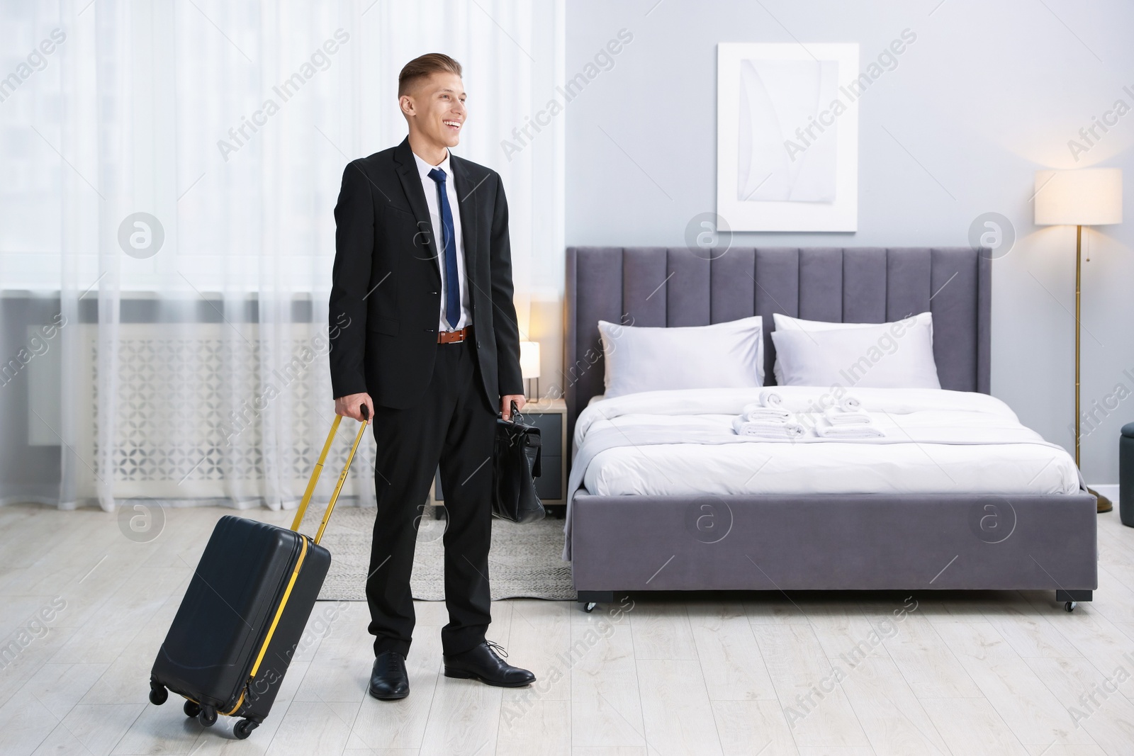 Photo of Businessman with suitcase and briefcase in hotel room