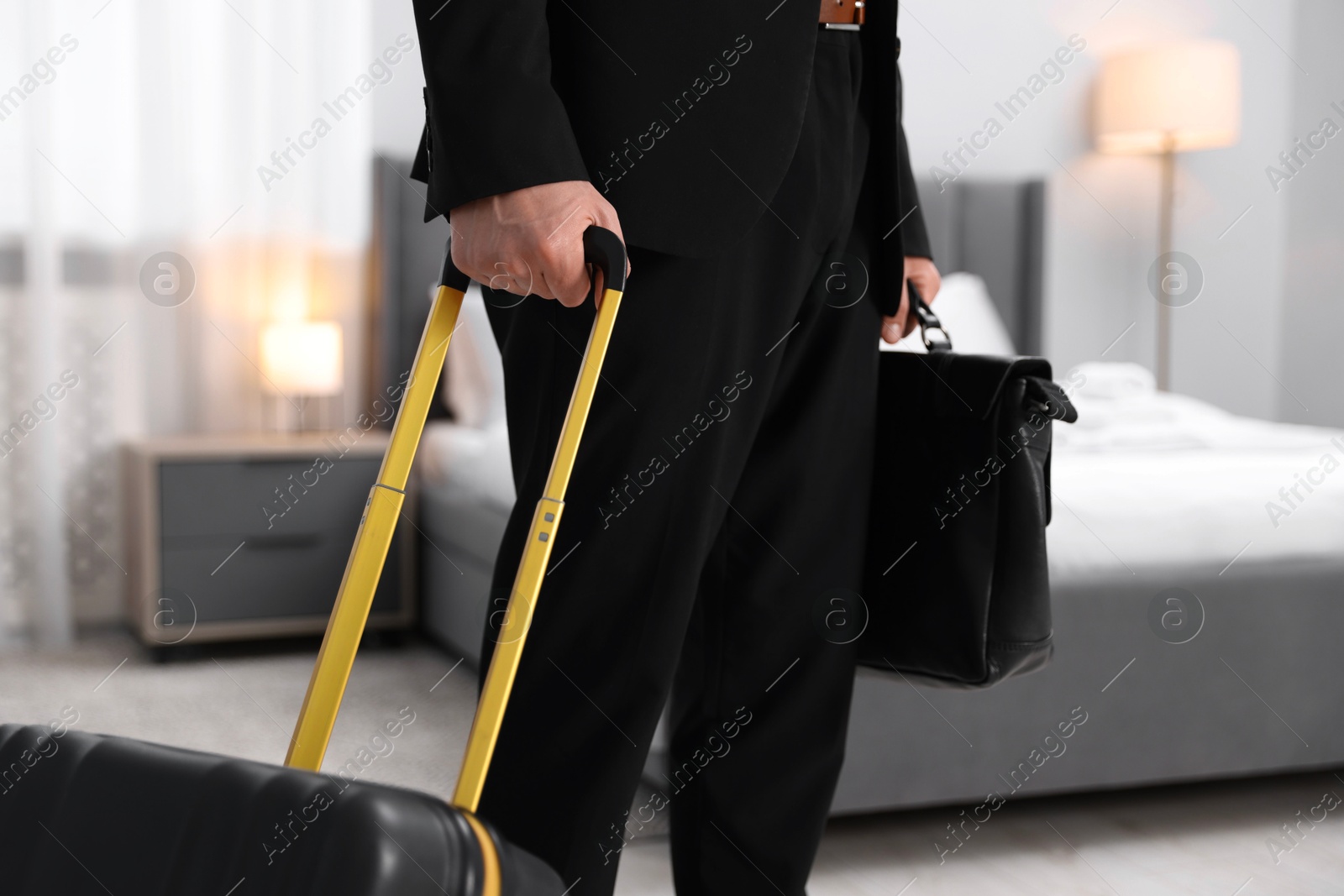 Photo of Businessman with suitcase and briefcase in hotel room, closeup