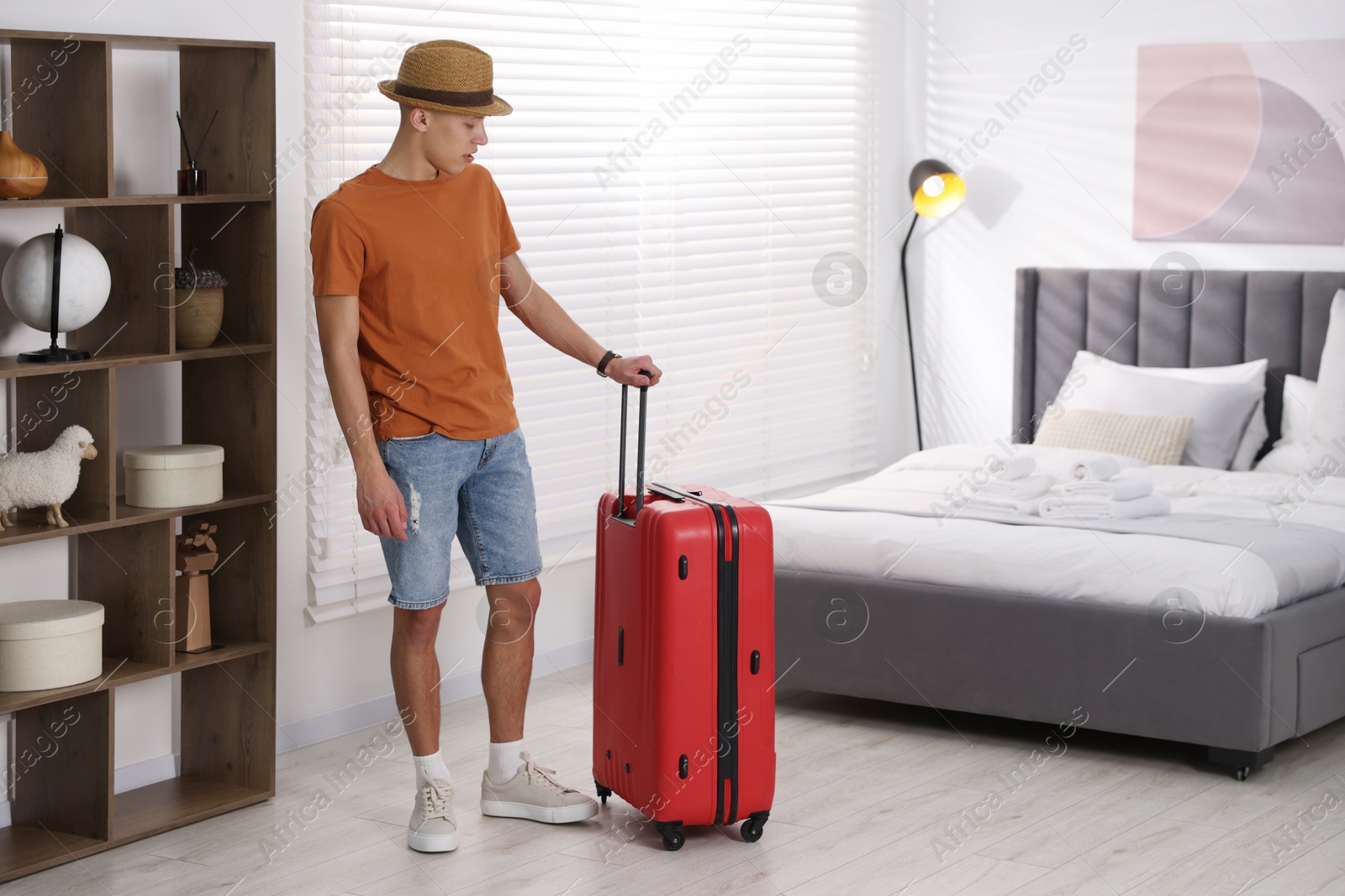 Photo of Man with suitcase in his hotel room