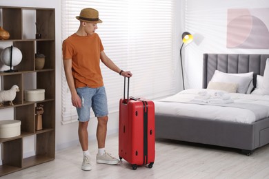 Man with suitcase in his hotel room