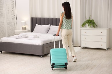 Woman with suitcase in her hotel room