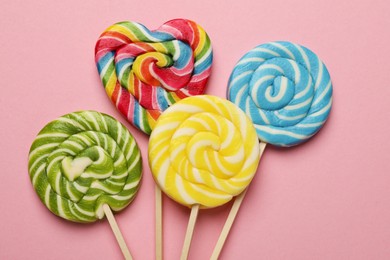 Tasty lollipops on pink background, flat lay