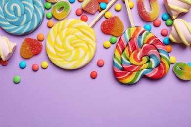 Photo of Many different tasty candies and marshmallows on violet background, flat lay. Space for text