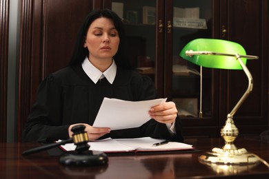 Judge working with documents at wooden table in office