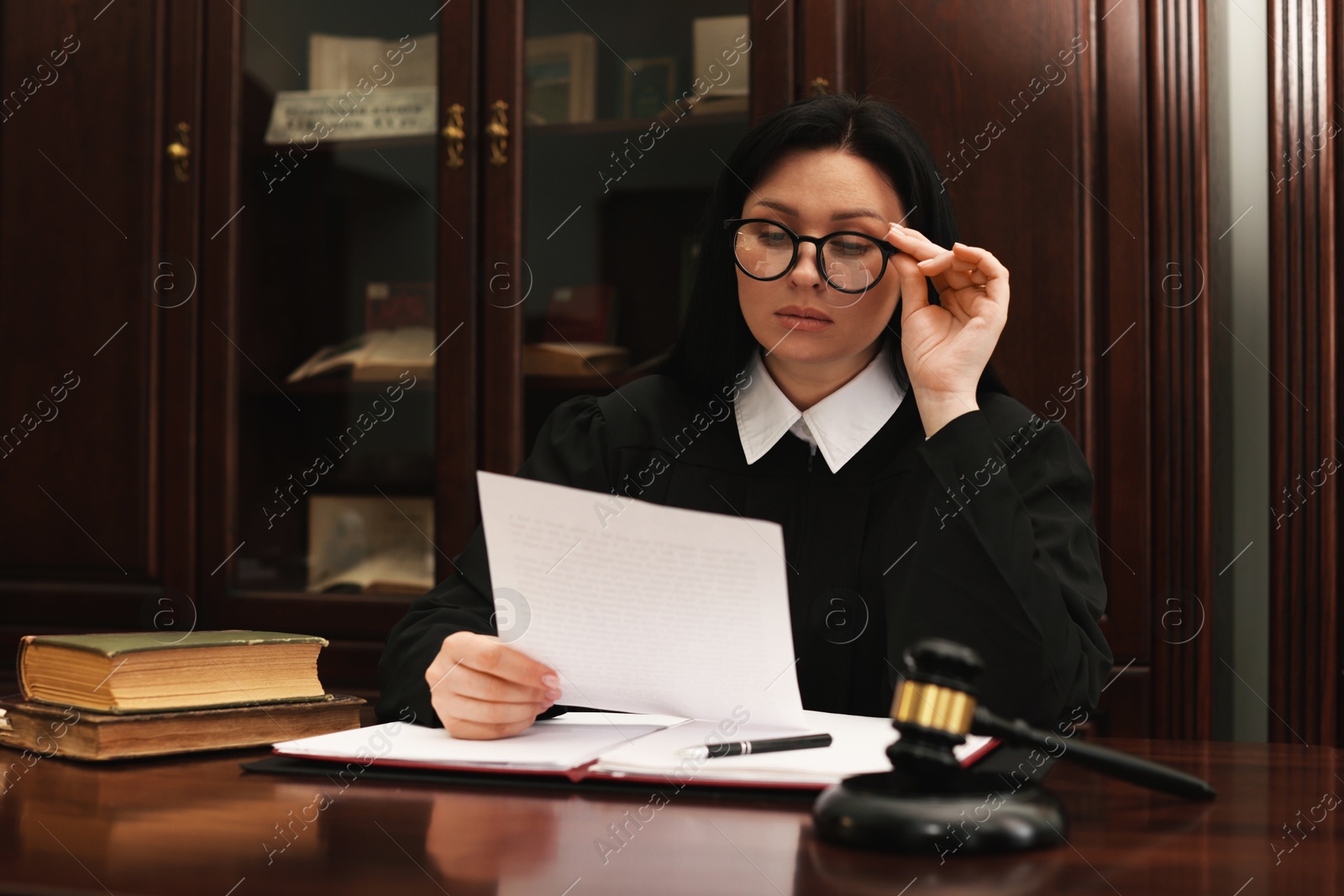 Photo of Judge with document at table in office