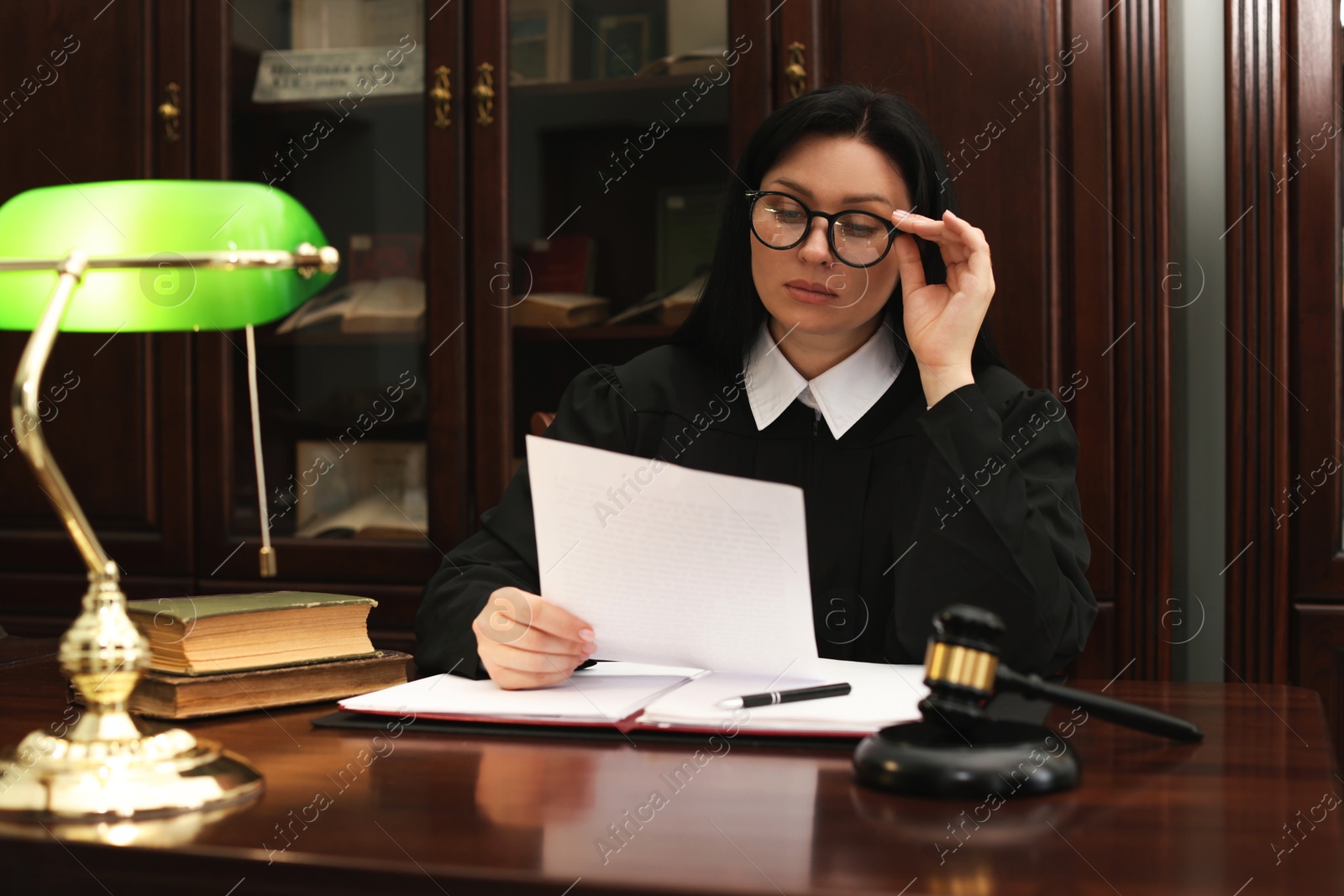 Photo of Judge with document at table in office