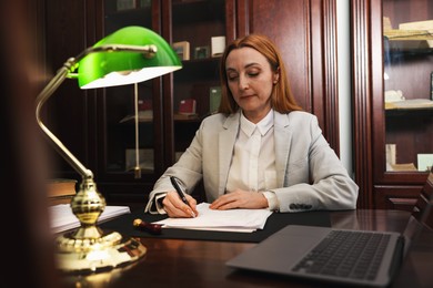 Notary doing paperwork at table in office