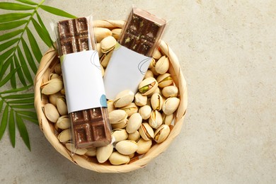 Photo of Delicious Dubai chocolate bars, pistachios and leaves on light background, top view. Space for text