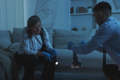 Photo of Forensic experts working at crime scene indoors