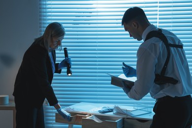 Photo of Forensic experts working at crime scene indoors