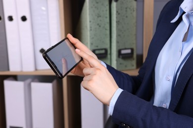 Photo of Electronic signature. Woman using smartphone indoors, closeup