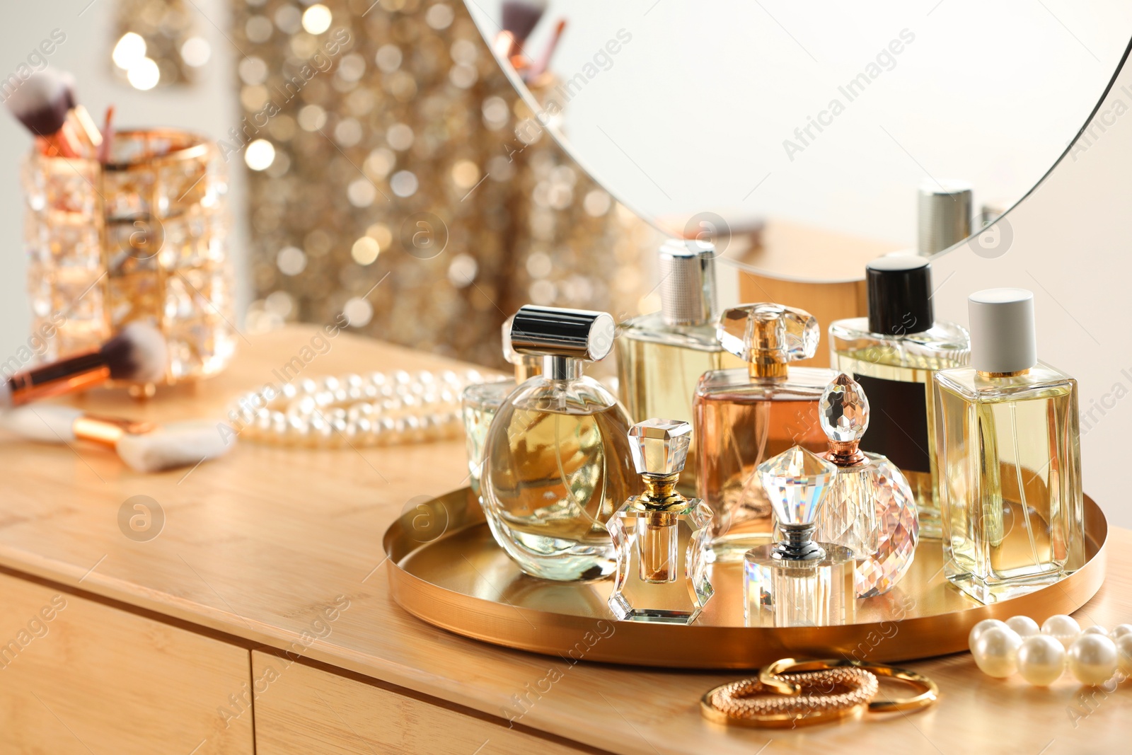 Different luxury perfumes on wooden dressing table indoors Photo of Different luxury perfumes on wooden dressing table indoors