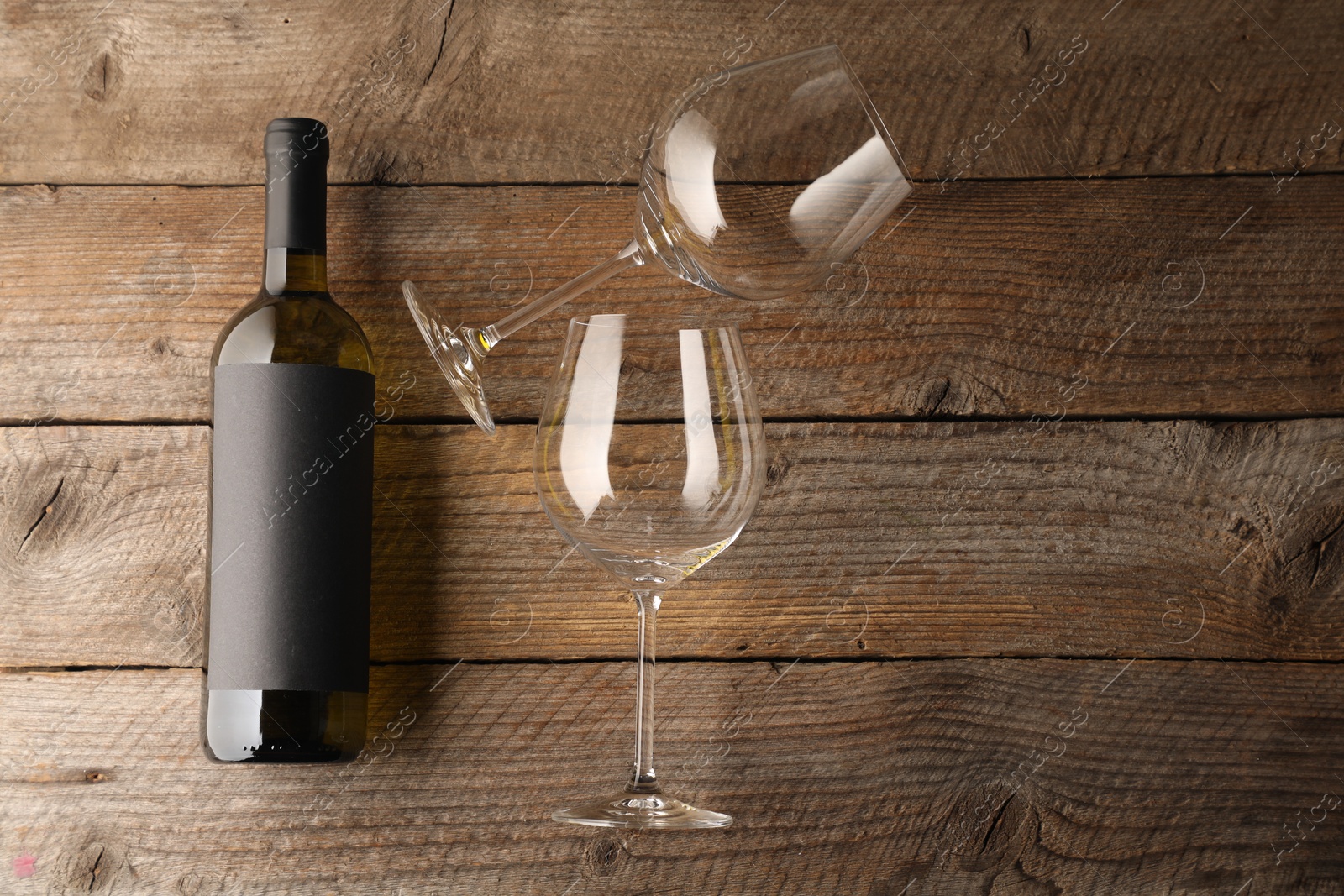 Bottle of wine and glasses on wooden table, flat lay. Space for text Photo of Bottle of wine and glasses on wooden table, flat lay. Space for text