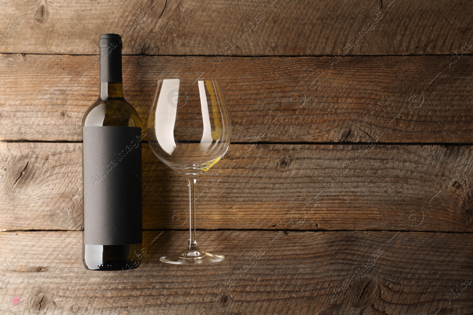 Bottle of wine and glass on wooden table, flat lay. Space for text Photo of Bottle of wine and glass on wooden table, flat lay. Space for text