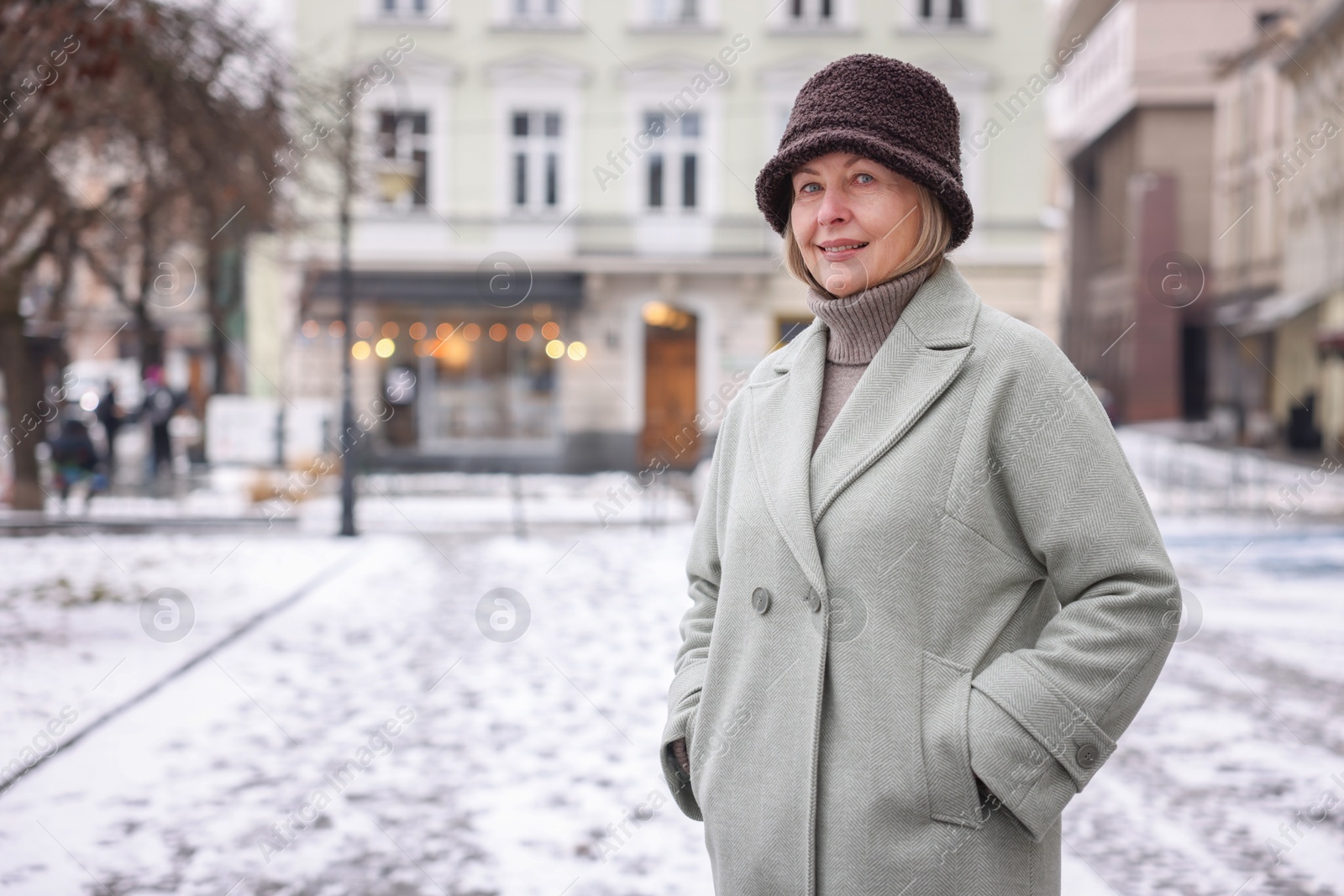 Photo of Smiling senior woman on city street. Space for text