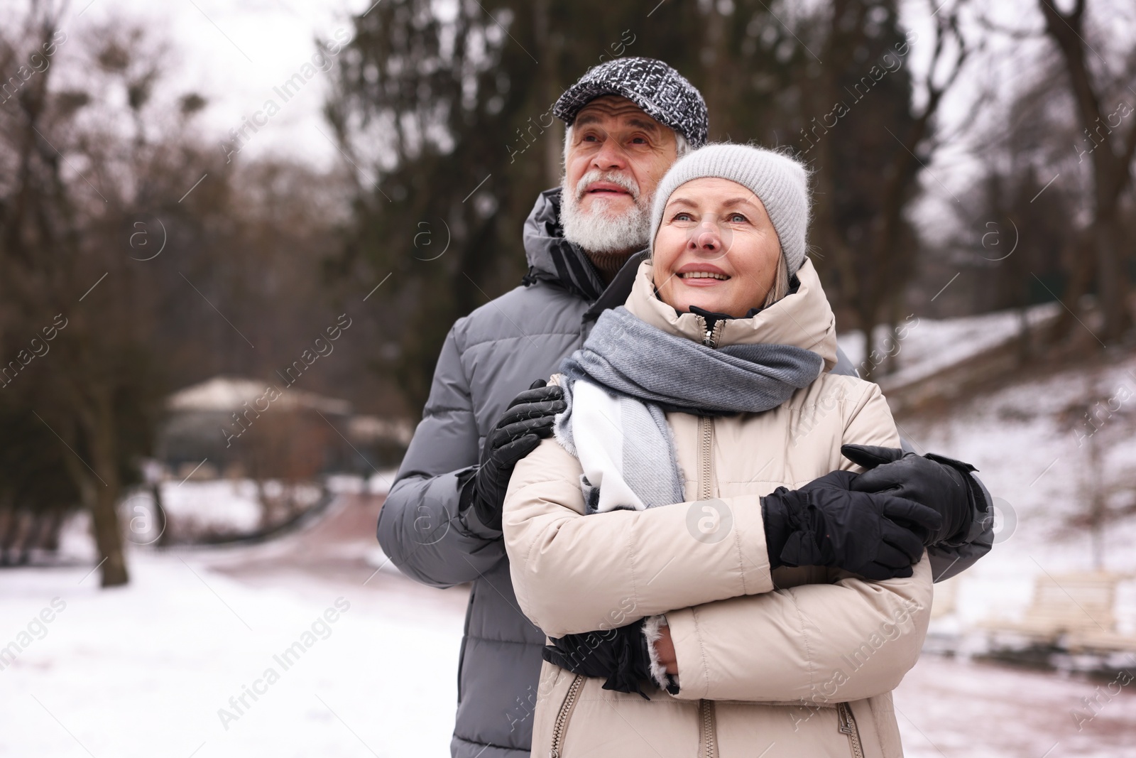 Photo of Happy senior couple at winter park. Space for text