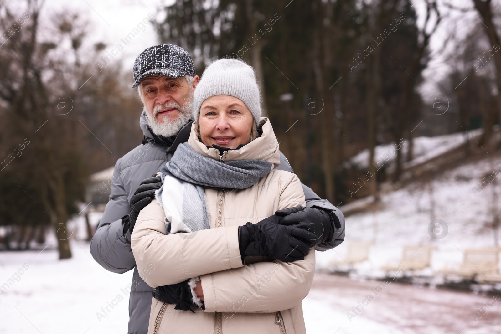 Photo of Portrait of happy senior couple at winter park. Space for text