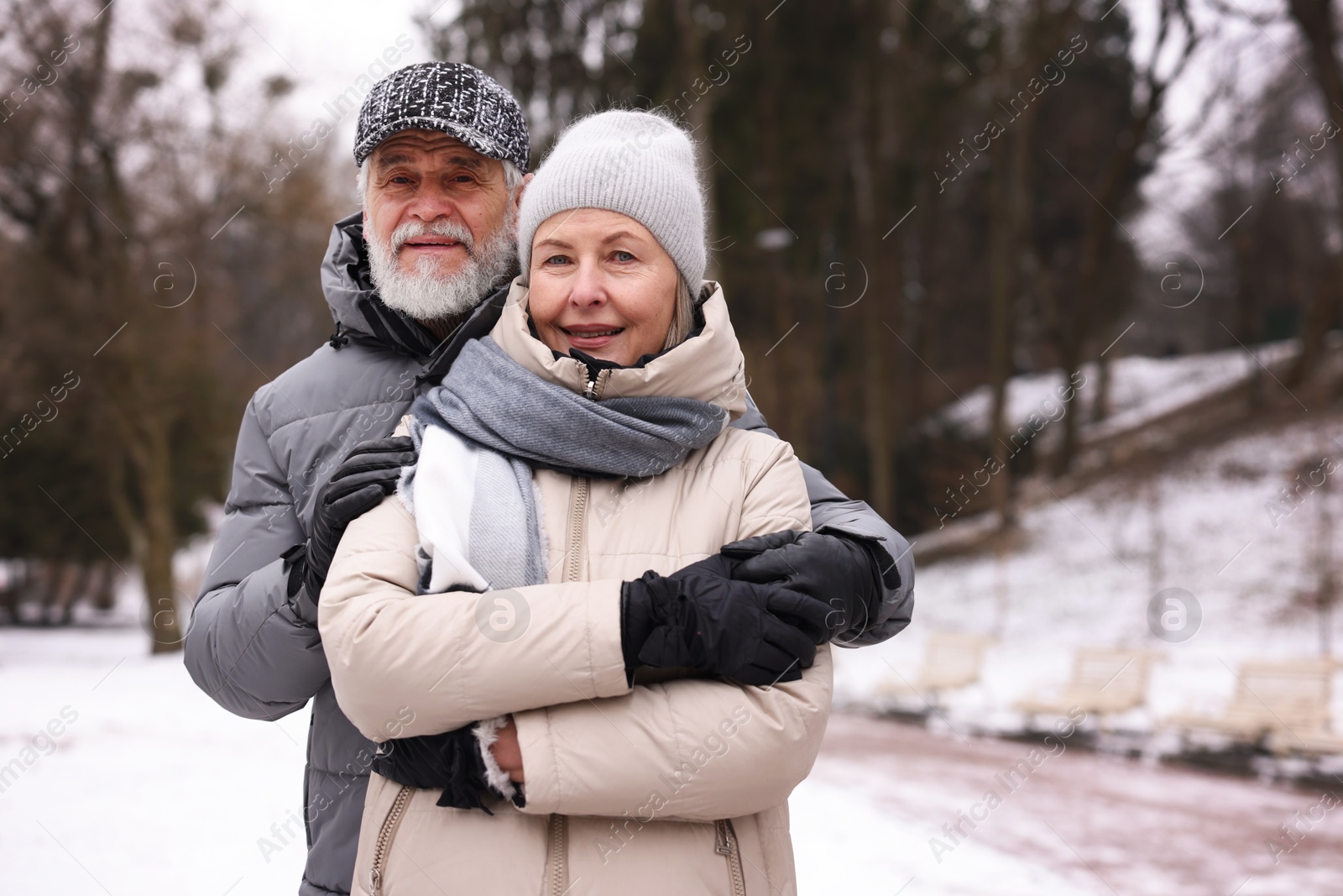 Photo of Portrait of happy senior couple at winter park. Space for text