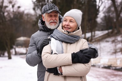 Happy senior couple walking at winter park