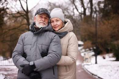 Photo of Lovely senior couple at winter park. Space for text