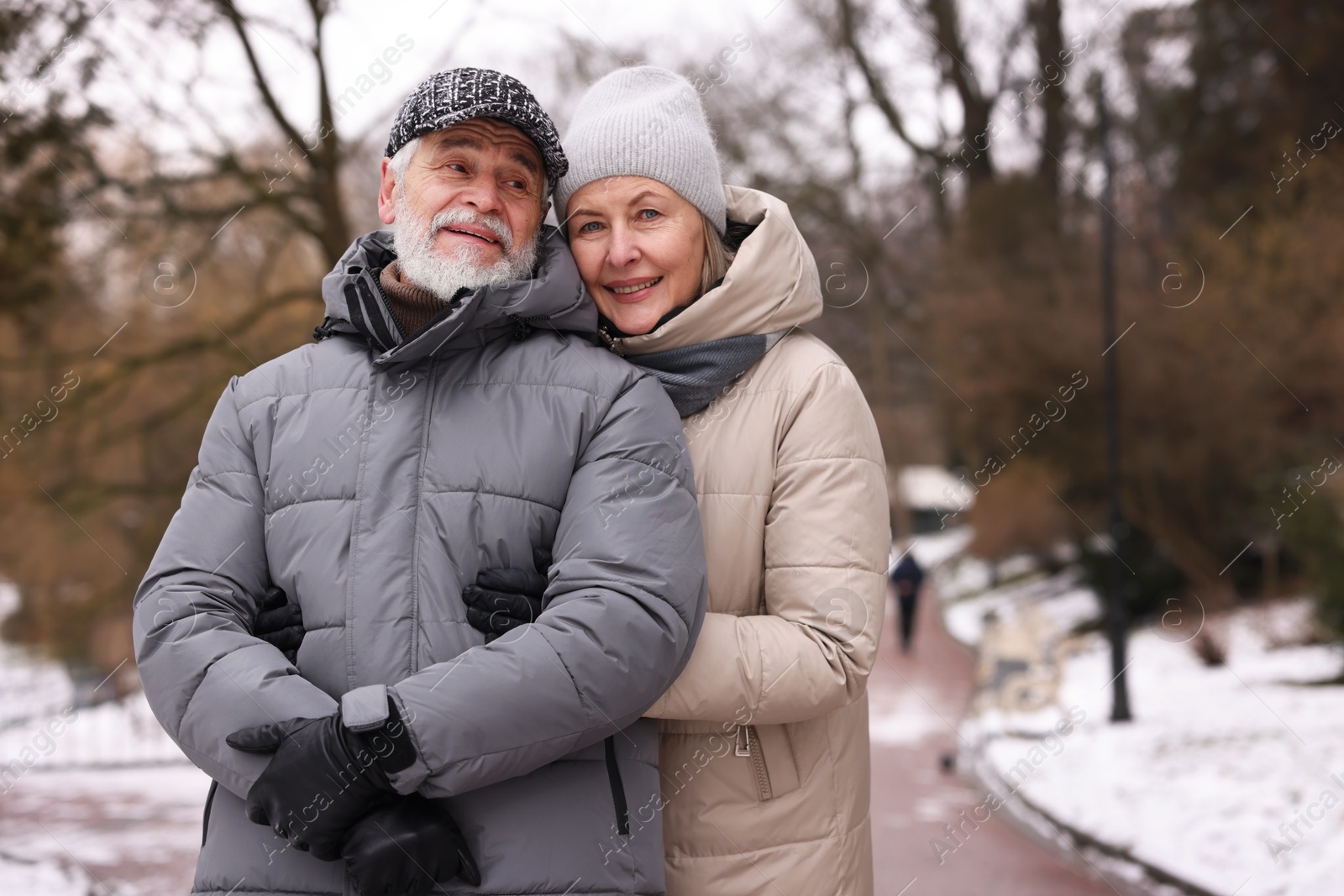 Photo of Happy senior couple at winter park. Space for text