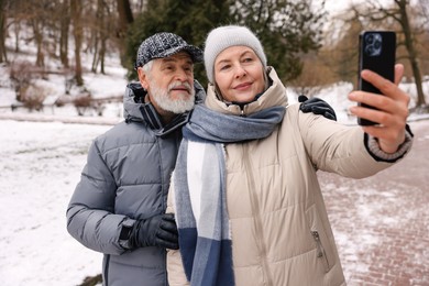 Photo of Lovely senior couple taking selfie at winter park