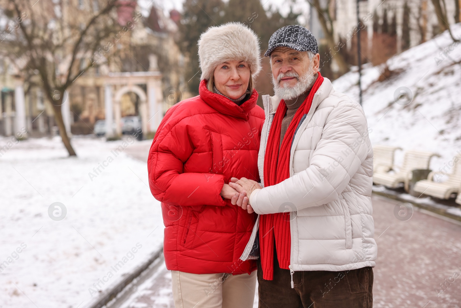 Photo of Lovely senior couple holding hands on winter day. Space for text