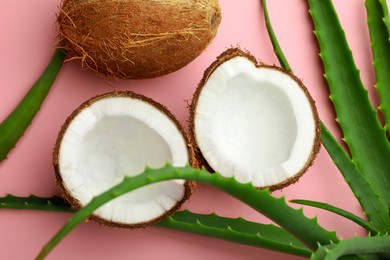 Photo of Hair treatment. Fresh coconut and aloe leaves on pink background, flat lay