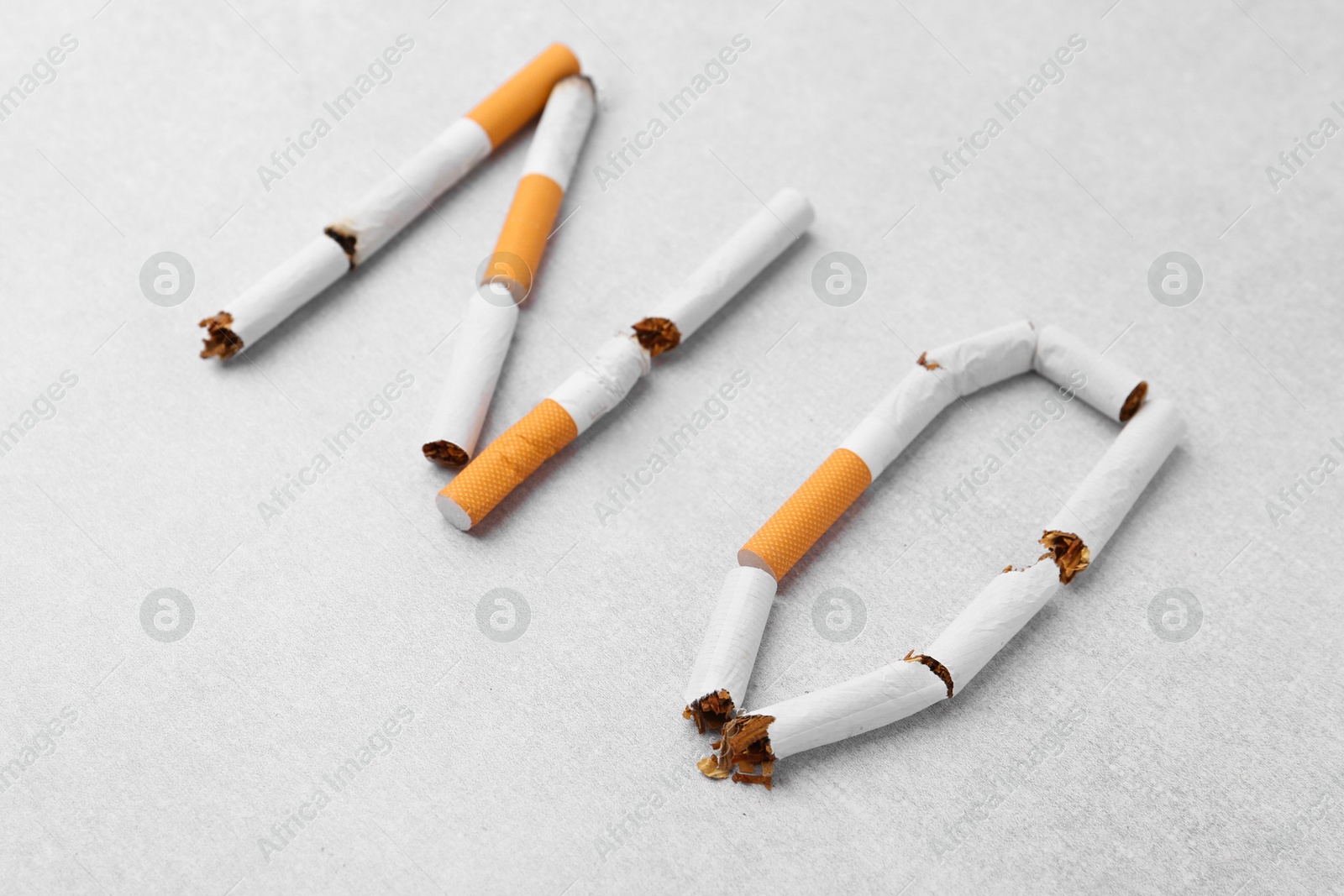 Photo of Word NO made with cigarette butts on light gray background