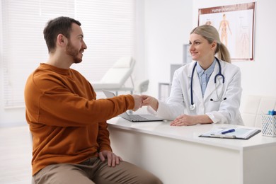 Doctor and patient shaking hands in hospital