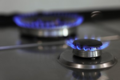 Gas burners with blue flame on stove, closeup